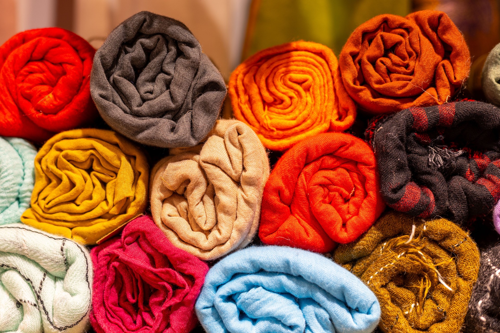 Tissu roulé coloré exposé sur un marché textile à midi dans une zone commerçante animée